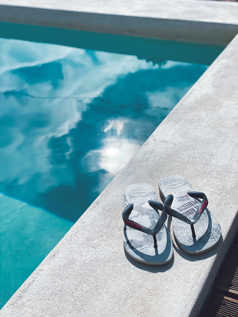 Photo par Lara Gray and Black Sandals on Gray Concrete Surface